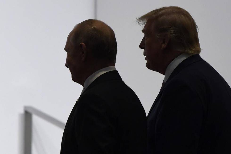 FILE - In this June 28, 2019, file photo, President Donald Trump and Russian President Vladimir Putin walk to participate in a group photo at the G20 summit in Osaka, Japan. An odd new front in the U.S.-Russian rivalry has emerged as a Russian military cargo plane bearing a load of urgently needed medical supplies landed in New Yorks JFK airport. (AP Photo/Susan Walsh, File)