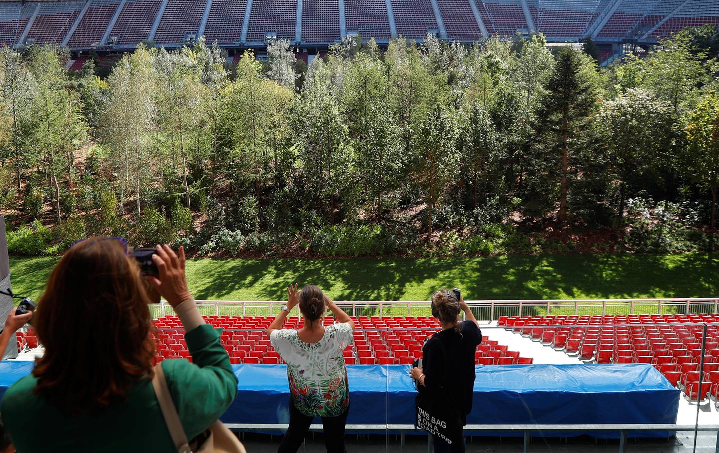People take pictures of the temporary art intervention by Swiss artist Klaus Littmann "FOR FOREST – The Unending Attraction of Nature" on the Woerthersee Stadium in Klagenfurt, Austria September 5, 2019.   REUTERS/Leonhard Foeger