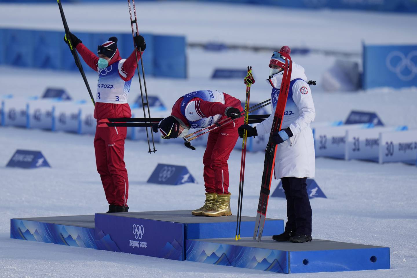 Sølvvinner Ivan Jakimusjkin jubler, gullvinner Alexander Bolsjunov bukker og bronsevinner Simen Hegstad Krüger varmer seg i frakken.