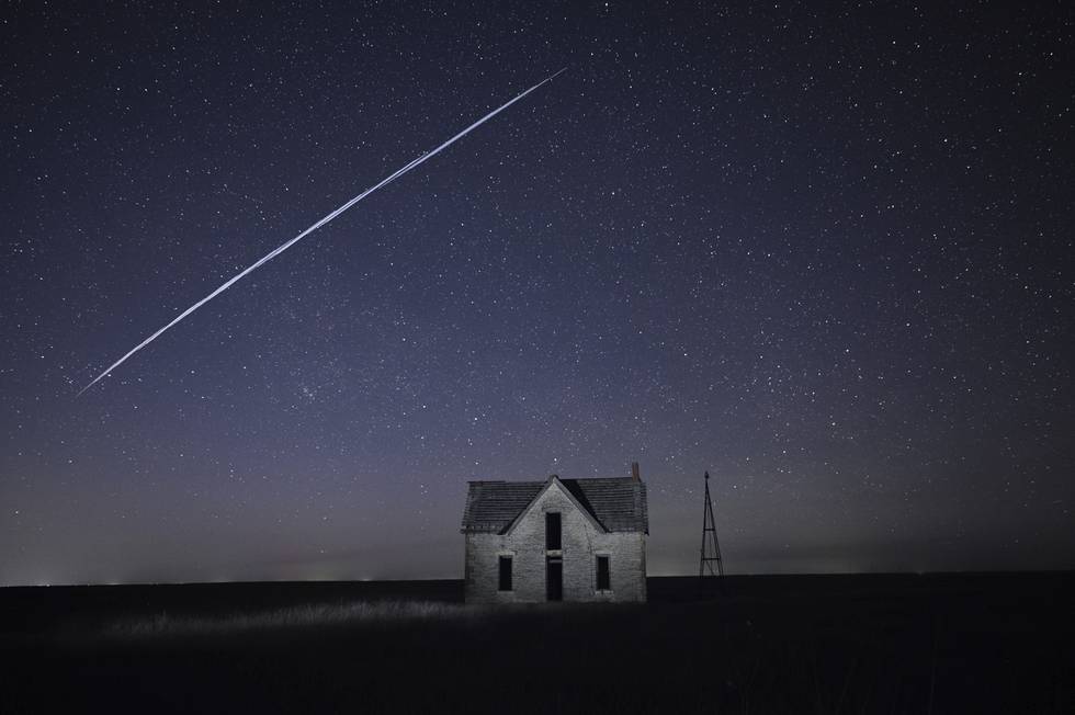 På dette bildet tegner en rekke Starlink-satellitter en stripe på nattehimmelen over et hus i Kansas. 40 satellitter som ble rammet av en solstorm, har falt tilbake mot jordens atmosfære der de brenner opp. Arkivfoto: Reed Hoffmann / AP / NTB
