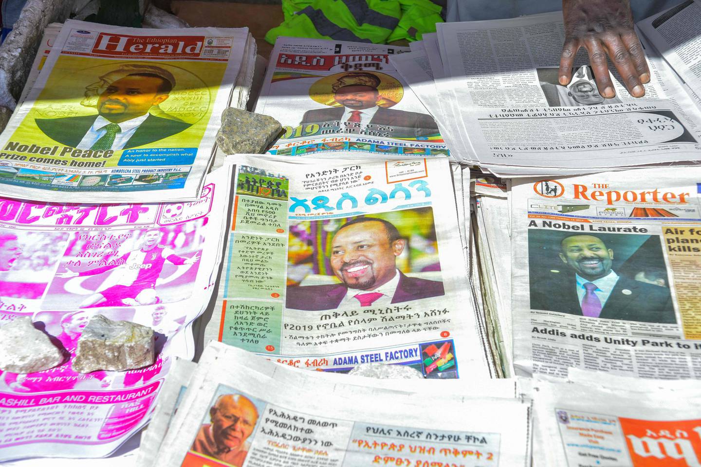 CORRECTION - The last edition of local newspapers are seen in Addis Ababa on October 12, 2019, with the news of Ethiopian Prime Minister Abiy Ahmed's award of The Nobel Peace Prize the previous day. - Ethiopian Prime Minister Abiy Ahmed was urged to press on with reforms and efforts to heal bitter tensions with neighbour Eritrea after he won the Nobel Peace Prize on October 11, 2019. Abiy, hailed by the Nobel Committee "for his efforts to achieve peace and international cooperation", sparked a historic rapprochement with longtime foe Eritrea soon after coming to power last year. (Photo by Michael TEWELDE / AFP) / ?The erroneous mention appearing in the metadata of this photo has been modified in AFP systems in the following manner: Byline should read [Michael TEWELDE] instead of [Tony KARUMBA].  Please immediately remove the erroneous mention[s] from all your online services and delete it (them) from your servers. If you have been authorized by AFP to distribute it (them) to third parties, please ensure that the same actions are carried out by them. Failure to promptly comply with these instructions will entail liability on your part for any continued or post notification usage. Therefore we thank you very much for all your attention and prompt action. We are sorry for the inconvenience this notification may cause and remain at your disposal for any further information you may require.?