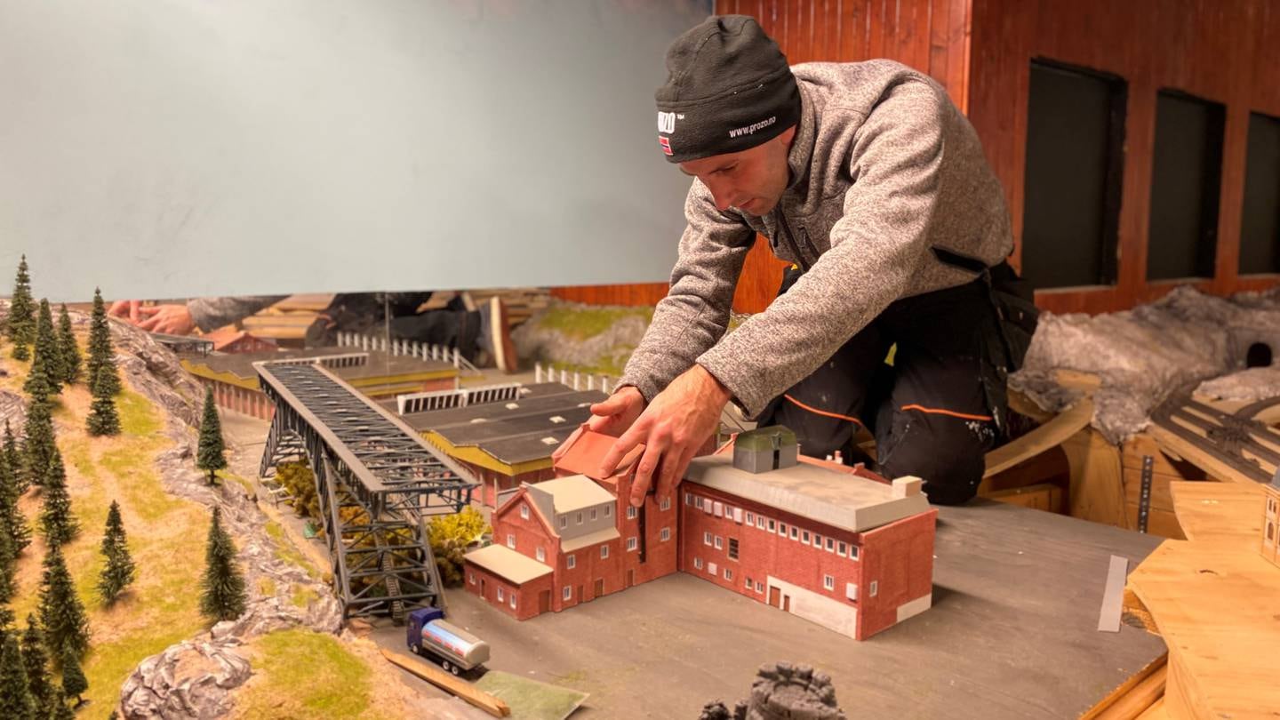 Haakon-Christian Oehninger-Storvoll legger siste hånd på verket på modellen av Mills-fabrikken som har fått plass i byggetrinn 3 ved Gamlebyen Modelljernbanesenter.