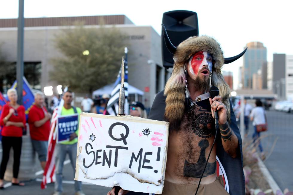 FILE - In this Nov. 5, 2020, file photo, Jacob Anthony Chansley, who also goes by the name Jake Angeli, a Qanon believer speaks to a crowd of President Donald Trump supporters outside of the Maricopa County Recorder's Office where votes in the general election are being counted, in Phoenix. In its annual report set to be released Monday, Feb. 1, 2021, the Southern Poverty Law Center said it identified 838 active hate groups operating across the U.S. in 2020. (AP Photo/Dario Lopez-Mills, File)