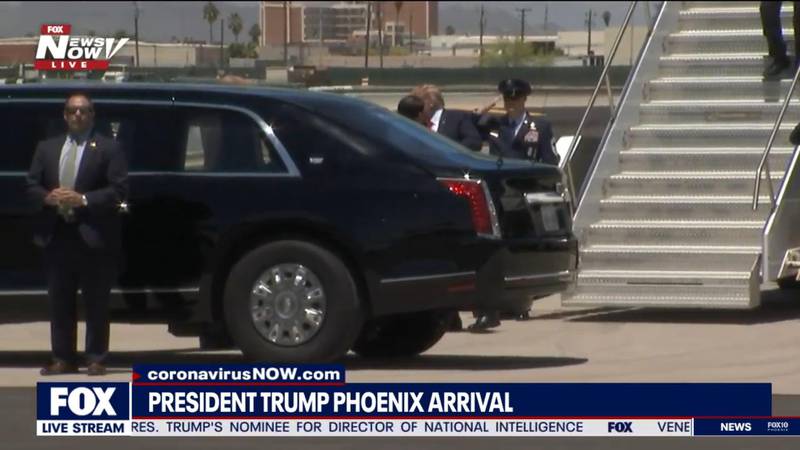 President Donald Trump håndhilser og klemmer på guvørnør Doug Ducey etter å ha kommet ut av Air Force One for besøket sitt til Phoenix, Arizona.