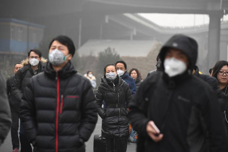 (FILES) This December 20, 2016 file photo shows commuters wearing masks on a polluted day in Beijing.  
The US exit from the Paris climate pact is a gift to China's ambitions to become world leader on everything from trade to global warming, despite its own mixed record. China is the world's top polluter but also its biggest investor in renewable energy and it has pledged to reduce its reliance on carbon-belching coal and clear the toxic smog from its cities. / AFP PHOTO / Greg Baker / TO GO WITH UN-climate-US-diplomacy-China-politics, FOCUS by Allison JACKSON