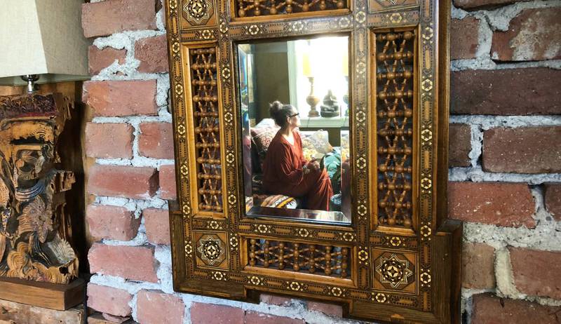 Rustikk: Et orientalsk speil pryder en autentisk murvegg i stua.