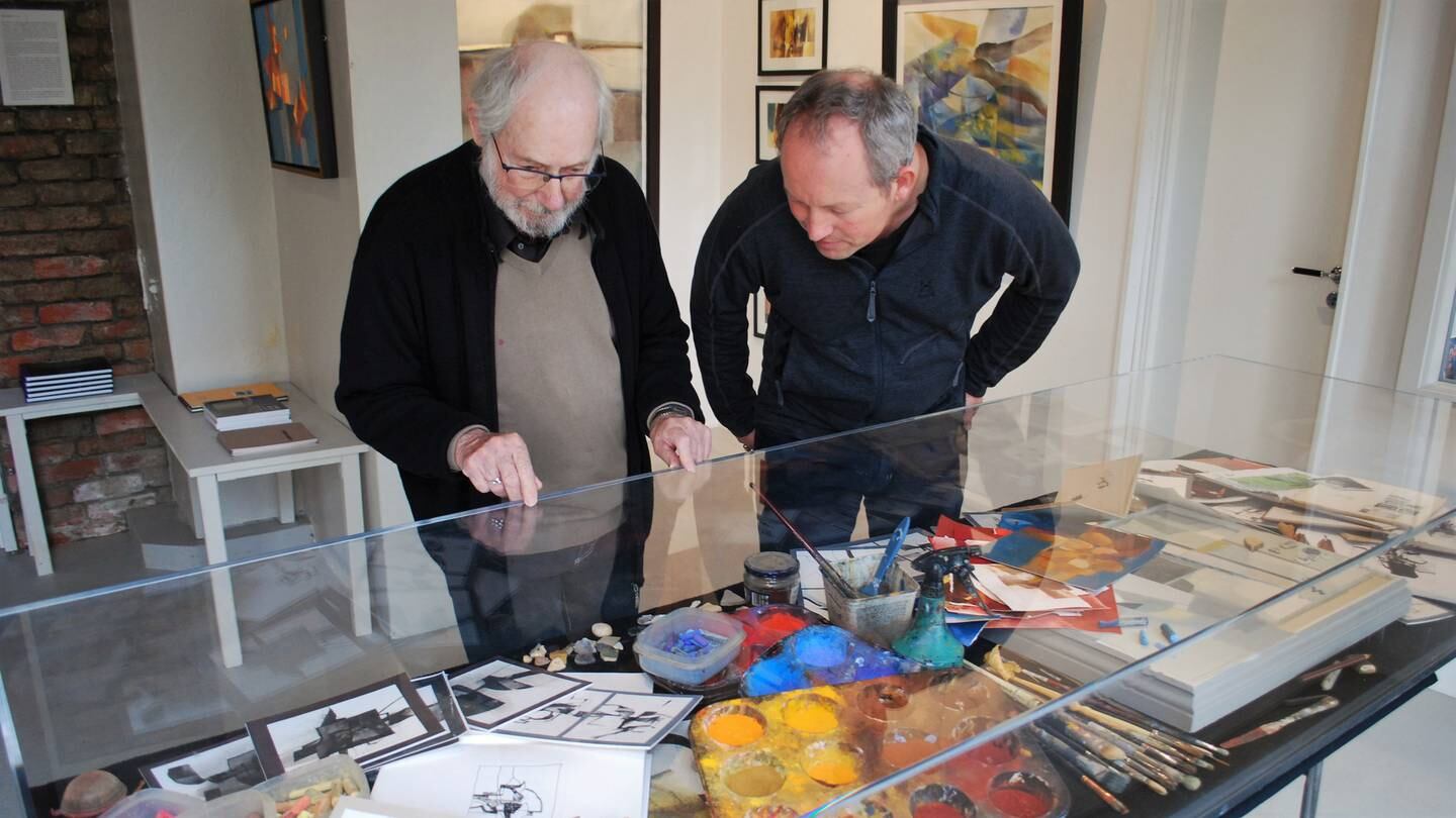 Kunstner Chris White (t.v.) og kollega og gallerist Lars Ole Klavestad studerer skisser og maleutstyr som stilles ut ved Galleri Klavestad i anledning Whites 85-årsdag.