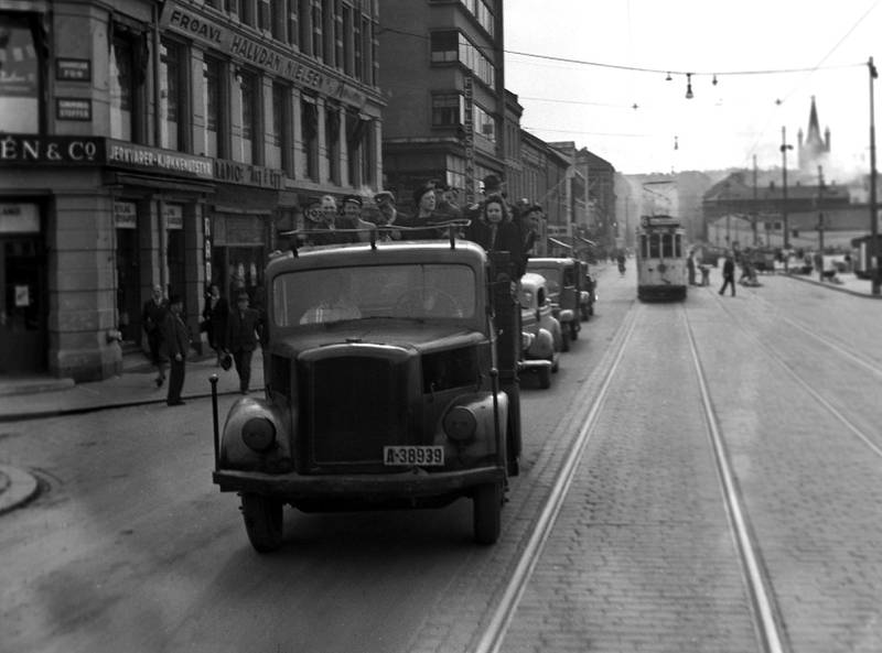 Oslo, i juni 1945. Det er fred, og det store landssvikoppgjøret er så smått i gang. Bildet viser arresterte NS-folk og andre som fraktes til retten med lastebil. 
