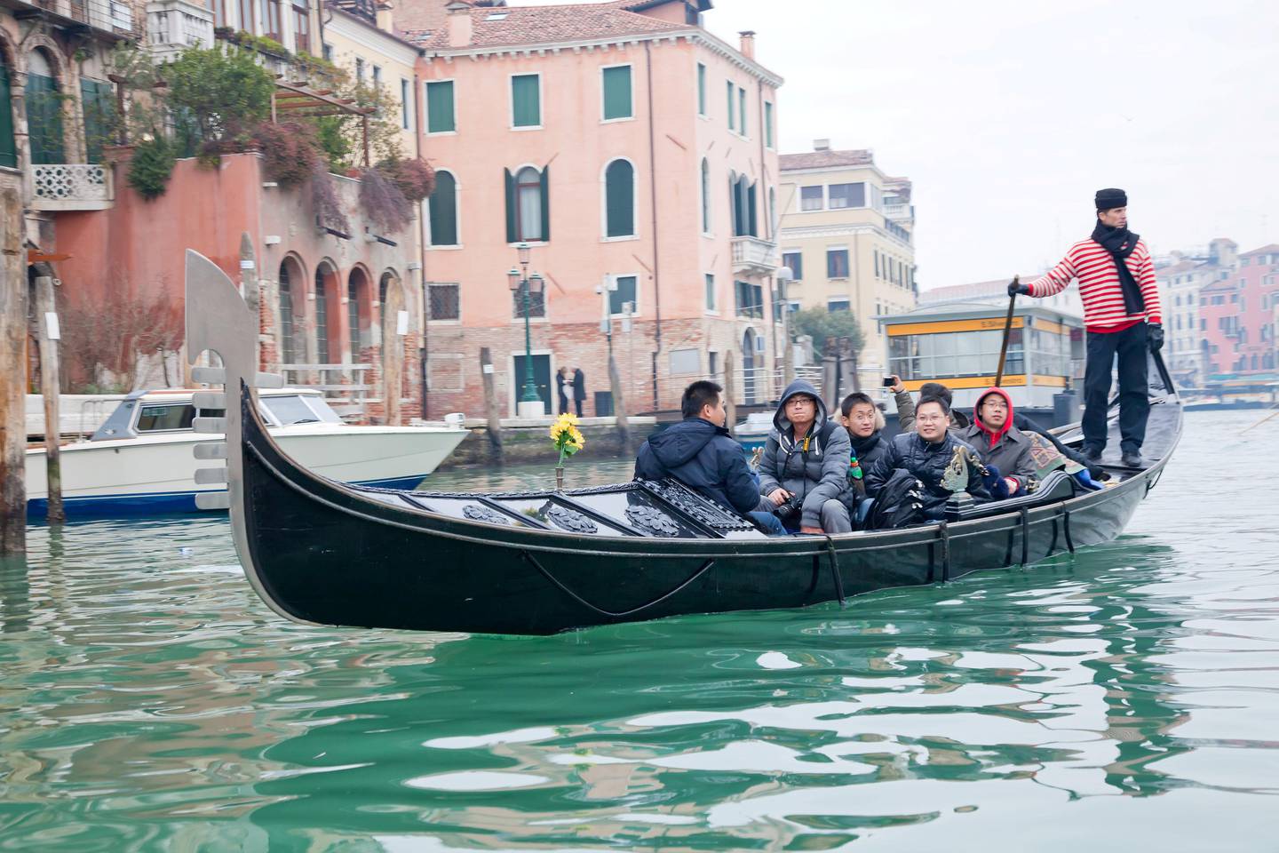 "Venice, Italy, January 1, 2011. Gondolier sailing by Venice Grand channel with chinese tourists on board, in winter."