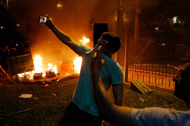 To menn tar selfier under opptøyene i Paraguays hovedstad Asunción fredag. 