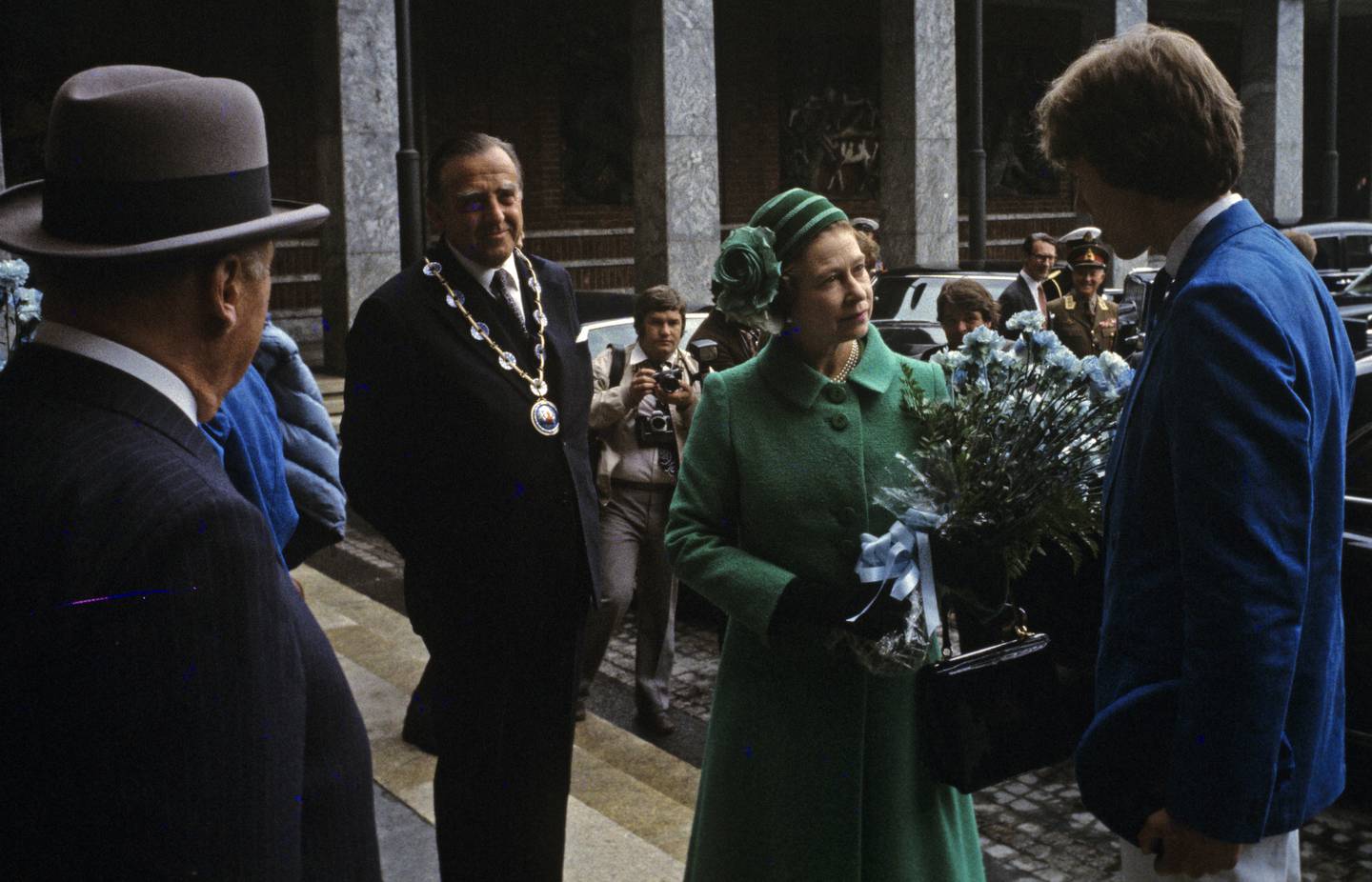 Dronning Elizabeth på offisielt besøk i Norge i mai 1981. Her får dronningen blomster av det årets russepresident, Rolv Erik Ryssdal. Kong Olav og Oslos ordfører Albert Nordengen (H) til venstre. Foto: NTB