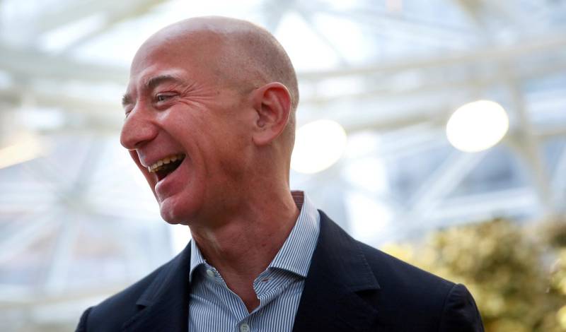 FILE PHOTO: FILE PHOTO: Amazon founder and CEO Jeff Bezos laughs as he talks to the media while touring the new Amazon Spheres during the grand opening at Amazon's Seattle headquarters in Seattle, Washington, U.S., January 29, 2018.   REUTERS/Lindsey Wasson/File Photo/File Photo