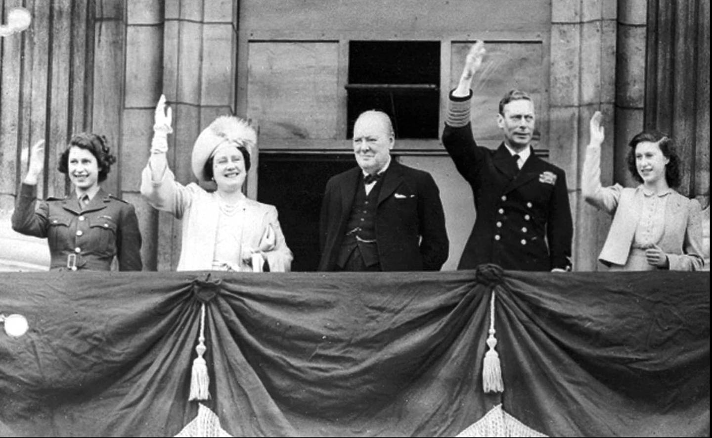 Dronning Elizabeth, som da var prinsesse, sammen med moren dronning Elizabeth, statsminister Winston Churchill, kong George VI og prinsesse Margaret på balkongen på Buckingham Palace på seiersdagen 8. mai 1945.
