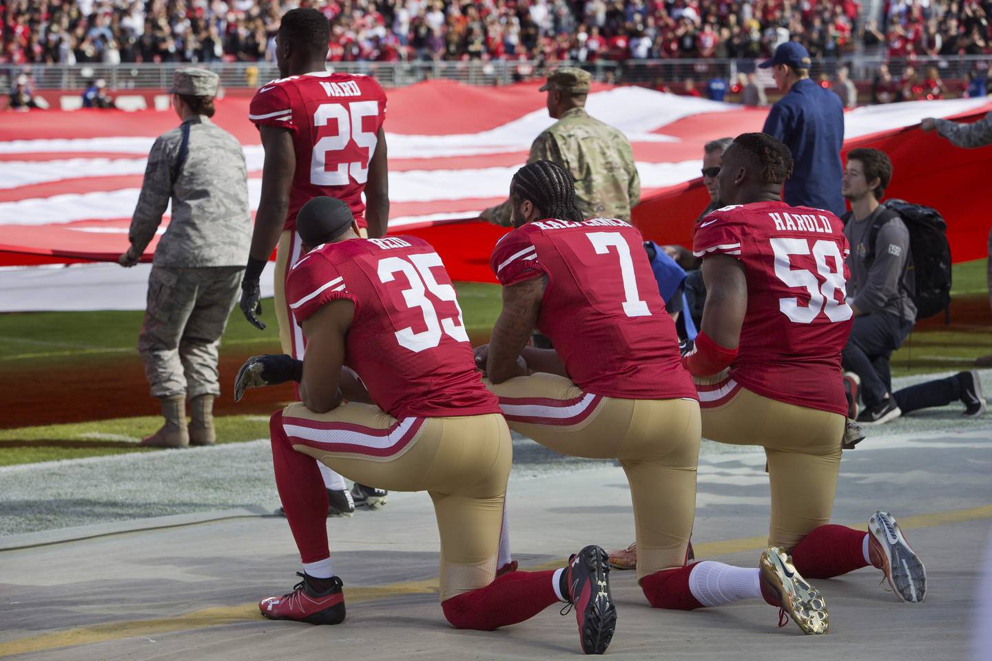 (FILES) In this file photo taken on November 6, 2016 Quarterback Colin Kaepernick #7, safety Eric Reid #35, and linebacker Eli Harold #58 of the San Francisco 49ers kneel before a game against the New Orleans Saints with the US flag unfurled in honor of the armed services  at Levi's Stadium in Santa Clara, California.
The NFL Players Association announced May 7, 2018 it has filed a grievance on behalf of Eric Reid, who lodged a collusion lawsuit against the league over being unsigned for kneeling during the US national anthem. Reid, a 26-year-old free agent safety who played from 2013 through last season with the San Francisco 49ers, was the first teammate to join former NFL quarterback Colin Kaepernick in a kneeling protest over social injustice and racial inequality issues. Kaepernick was unemployed during the 2017 NFL season after igniting the social protest among players that led US President Donald Trump to condemn the protests and urge owners fire players who kneeled during "The Star-Spangled Banner."
 / AFP PHOTO / GETTY IMAGES NORTH AMERICA / BRIAN BAHR