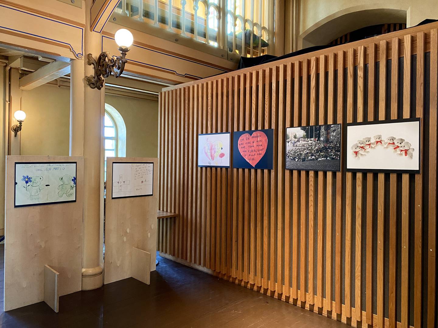 Utstillingen består av 12 bilder av tegninger, ord og gjenstander som ble lagt utenfor Domkirken.