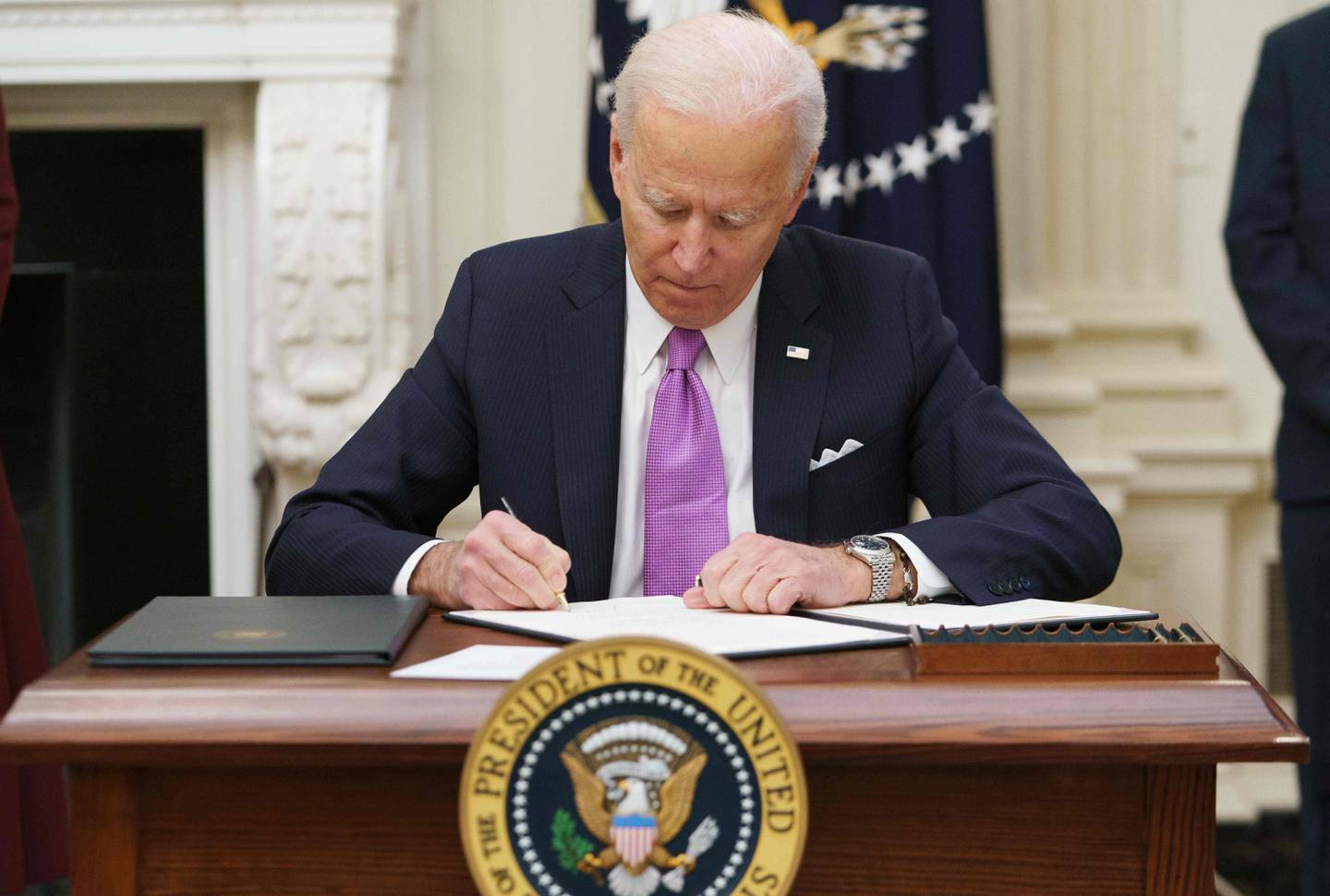 US President Joe Biden signs executive orders as part of the Covid-19 response in the State Dining Room of the White House in Washington, DC, on January 21, 2021. (Photo by MANDEL NGAN / AFP)