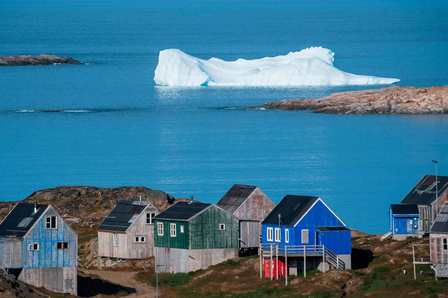 TOPSHOT - Icebergs float behind the town of Kulusuk in Greenland on August 16, 2019. - Greenland is not for sale, the mineral-rich island said on August 16, 2019, after a newspaper reported that US President Donald Trump was asking advisers whether it's possible for the United States to buy the Arctic island. (Photo by Jonathan NACKSTRAND / AFP)