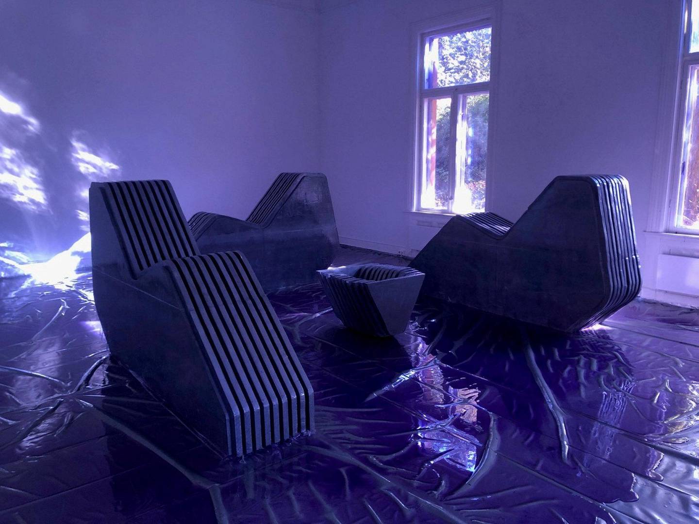 Tiril Hasselknippes installasjon med harde divaner er badet i et blått lys.
Foto: Silja Leifsdottir