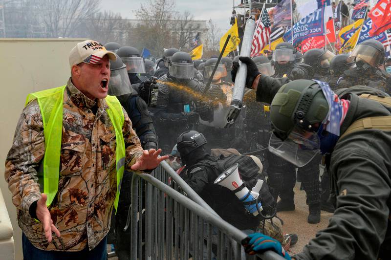 A Trump supporter screams towards police and security forces as demonstrators storm the US Capitol in Washington D.C on January 6, 2021. - Donald Trump's supporters stormed a session of Congress held today, January 6, to certify Joe Biden's election win, triggering unprecedented chaos and violence at the heart of American democracy and accusations the president was attempting a coup. (Photo by Joseph Prezioso / AFP)