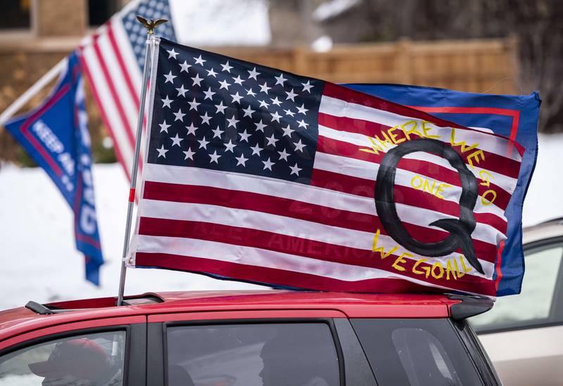 ST PAUL, MN - NOVEMBER 14: A car with a flag endorsing the QAnon drives by as supporters of President Donald Trump gather for a rally outside the Governor's Mansion on November 14, 2020 in St Paul, Minnesota. Thousands have gathered in cities around the country today to contest the results of the election earlier this month.   Stephen Maturen/Getty Images/AFP
== FOR NEWSPAPERS, INTERNET, TELCOS & TELEVISION USE ONLY ==