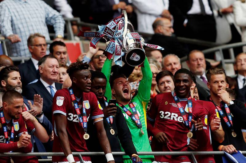 Aston Villa's players celebrate with the trophy after the English Championship play-off final football match between Aston Villa and Derby County at Wembley Stadium in London on May 27, 2019. - Aston Villa won the game 2-1, and are promoted to the Premier League. (Photo by Adrian DENNIS / AFP) / NOT FOR MARKETING OR ADVERTISING USE / RESTRICTED TO EDITORIAL USE