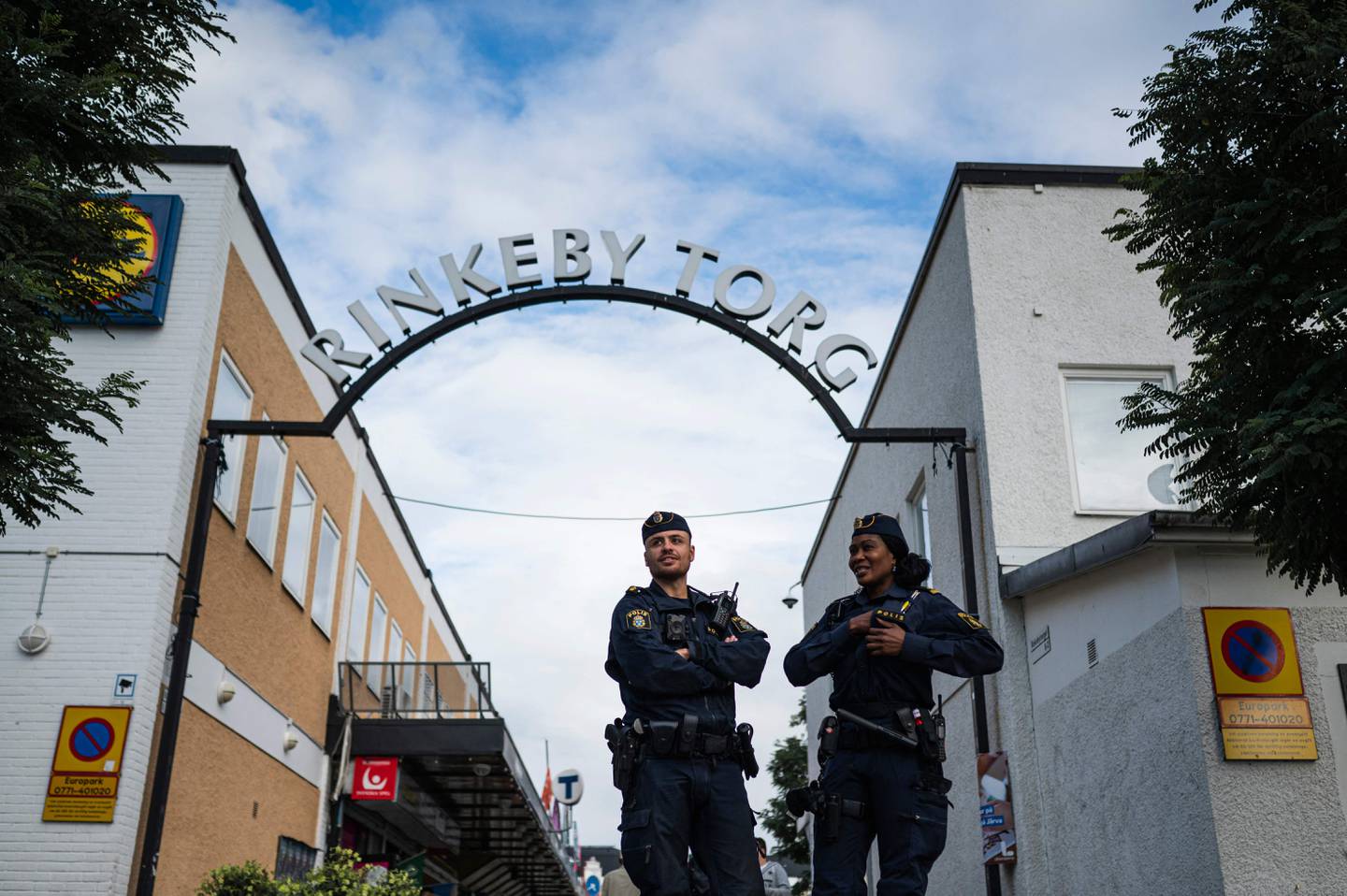 (FILES) Police officers Michael Cojocaru (L) and Rissa Seidou patrol the main square in Rinkeby, Sweden, on August 31, 2022. Sweden's government said On Bebruary 8, 2024 that it wanted to establish zones where police could search people even if they are not suspected of specific crimes, with such decisions potentially based on fashion choices associated with gangs. (Photo by Jonathan NACKSTRAND / AFP)