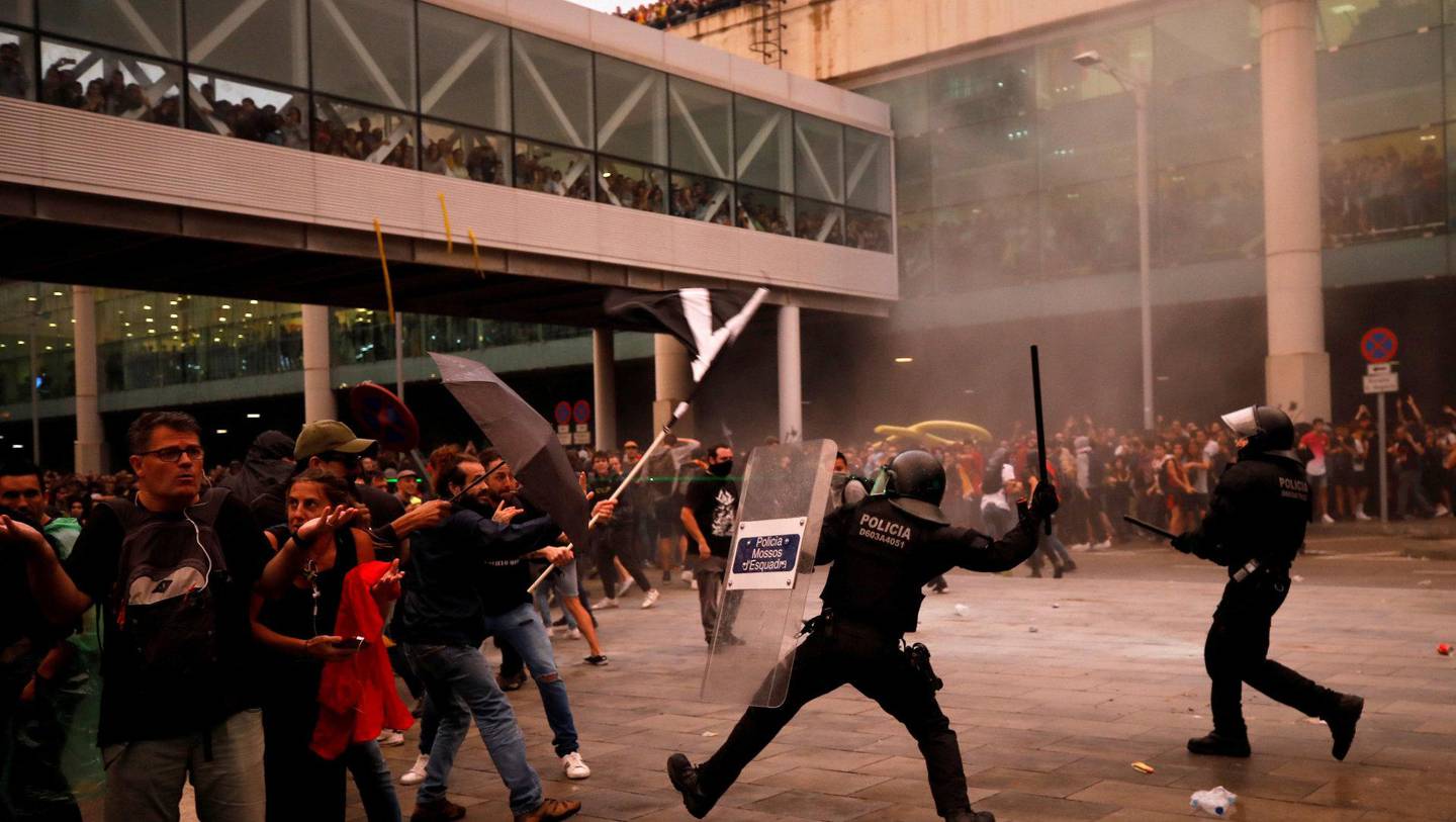 Det nasjonale politiet var på plass på flyplassen i Barcelona mandag. Flere demonstranter ble såret under markeringene. FOTO: NTB SCANPIX