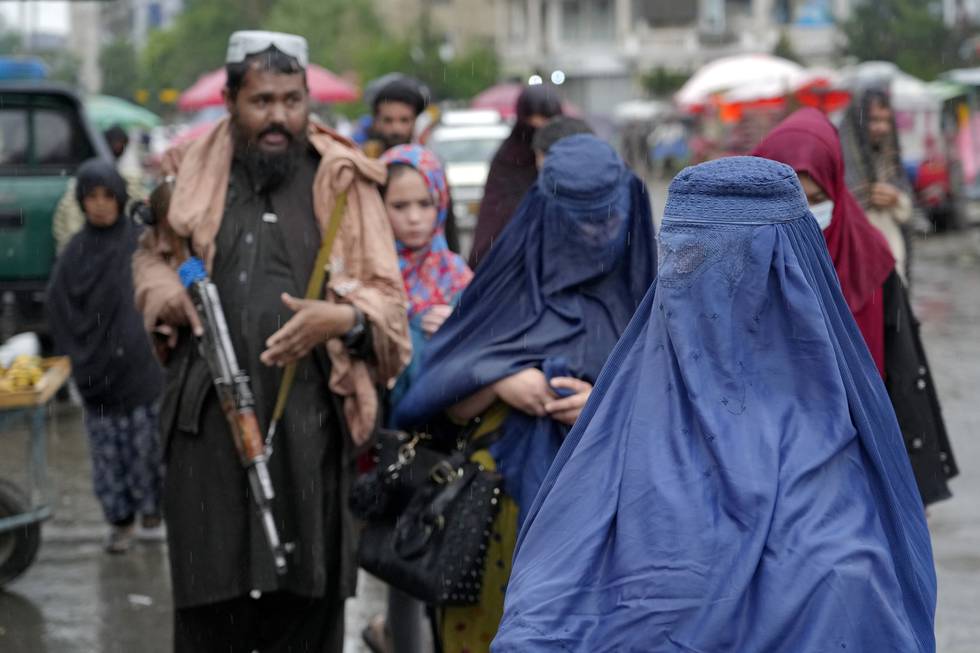 Afghanske kvinner på et marked i Kabul mens en Taliban-kriger passer på. Foto: Ebrahim Noroozi / AP / NTB