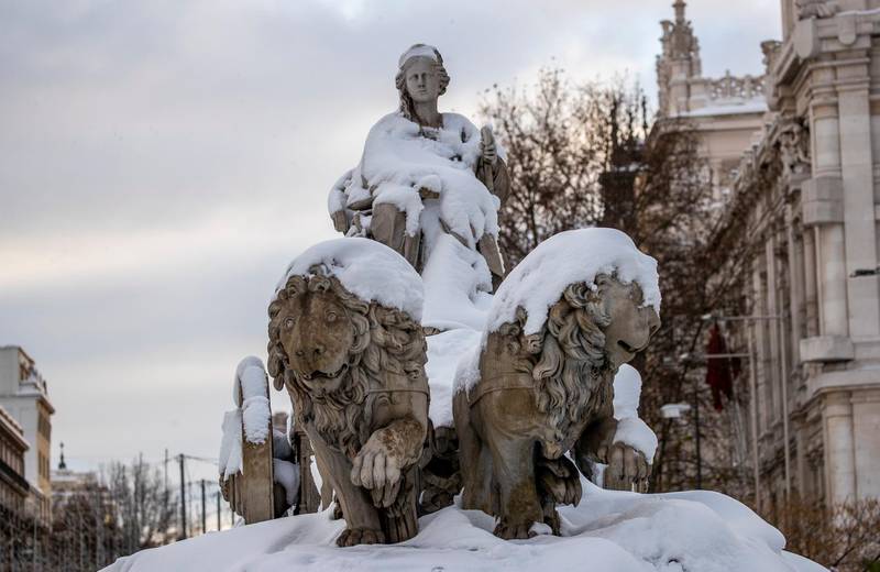 The Cibeles monument is covered with snow in downtown Madrid, Spain, Sunday, Jan. 10, 2021. A large part of central Spain including the capital of Madrid are slowly clearing snow after the country's worst snowstorm in recent memory. (AP Photo/Manu Fernandez)
