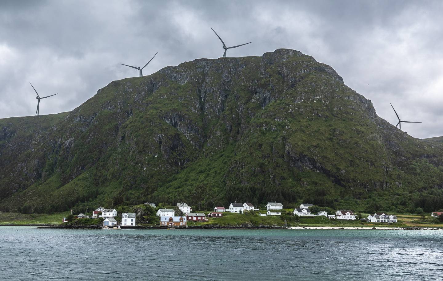 Tettstedet Ulla på Haramsøya i Ålesund kommune i Møre og Romsdal. Vindturbiner tilhørende Haram vindkraftverk på fjellet over tettstedet.