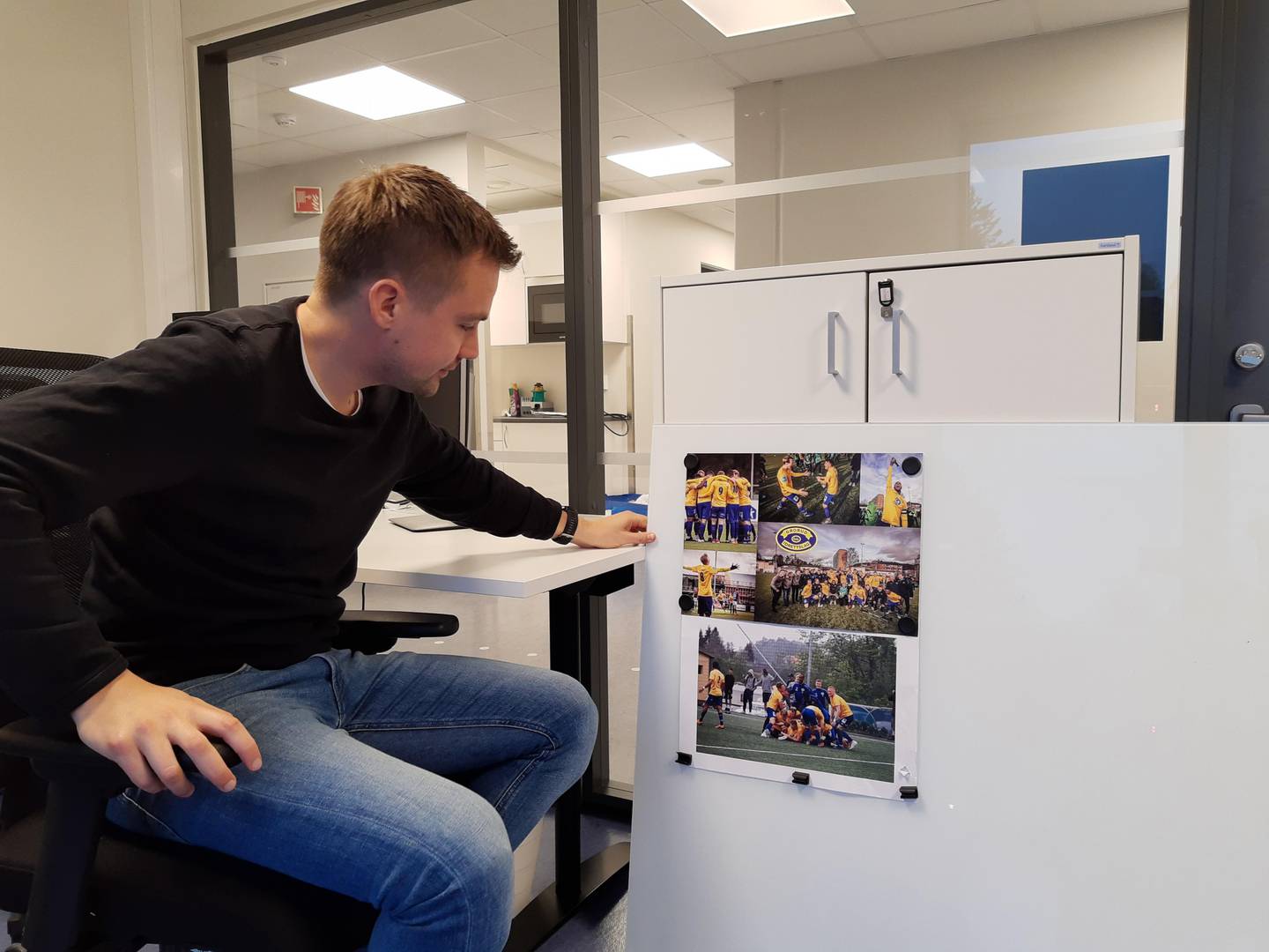 Eirik Kjønø kikker på bildene av opprykket for ett år siden. Nå på plass på sitt nye kontor.