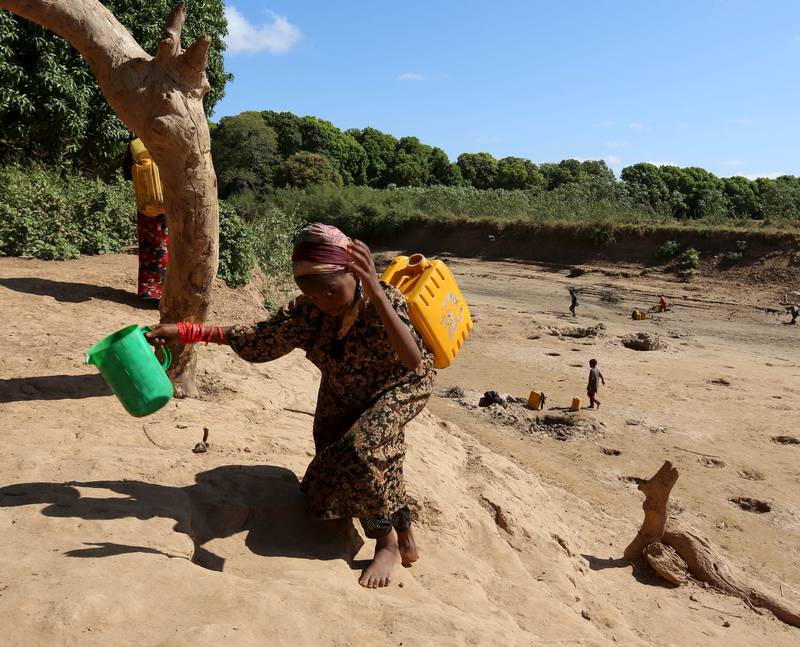 TØRKET ELV: En jente bærer en kanne vann fra en kilde nær Shabelle-elven i Somalia. FOTO: NTB SCANPIX