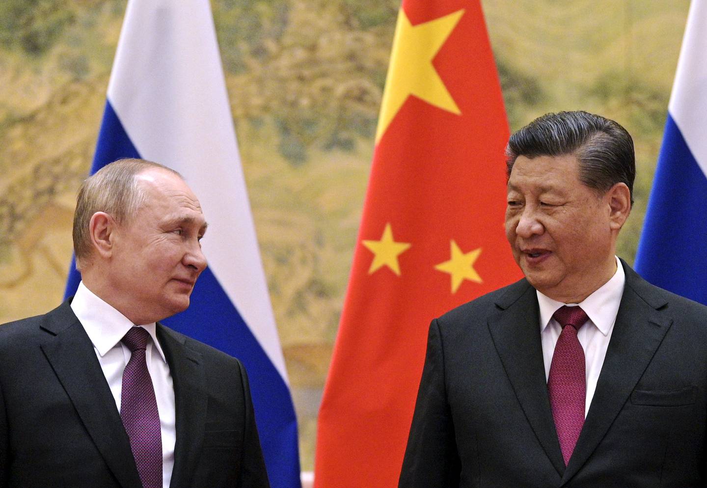 Kinas president Xi Jinping og Russlands Vladimir Putin står bak russiske og kinesiske flagg.