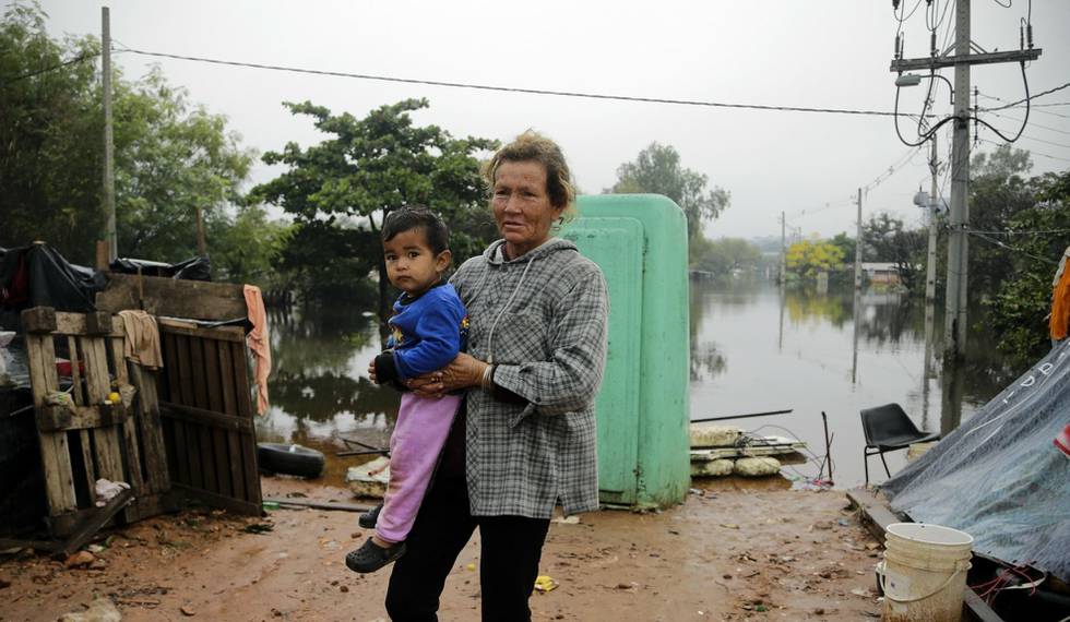 Marisol Coronel holds her grandson near their temporary shelter in the "Bañado Norte" neighborhood of Asuncion, Paraguay, Thursday, May 30, 2019. Unusually heavy downpours in the past month have resulted in widespread flooding displacing tens of thousands. Water levels of the Paraguay River continue to rise. (AP Photo/Jorge Saenz) (AP Photo/Jorge Saenz)