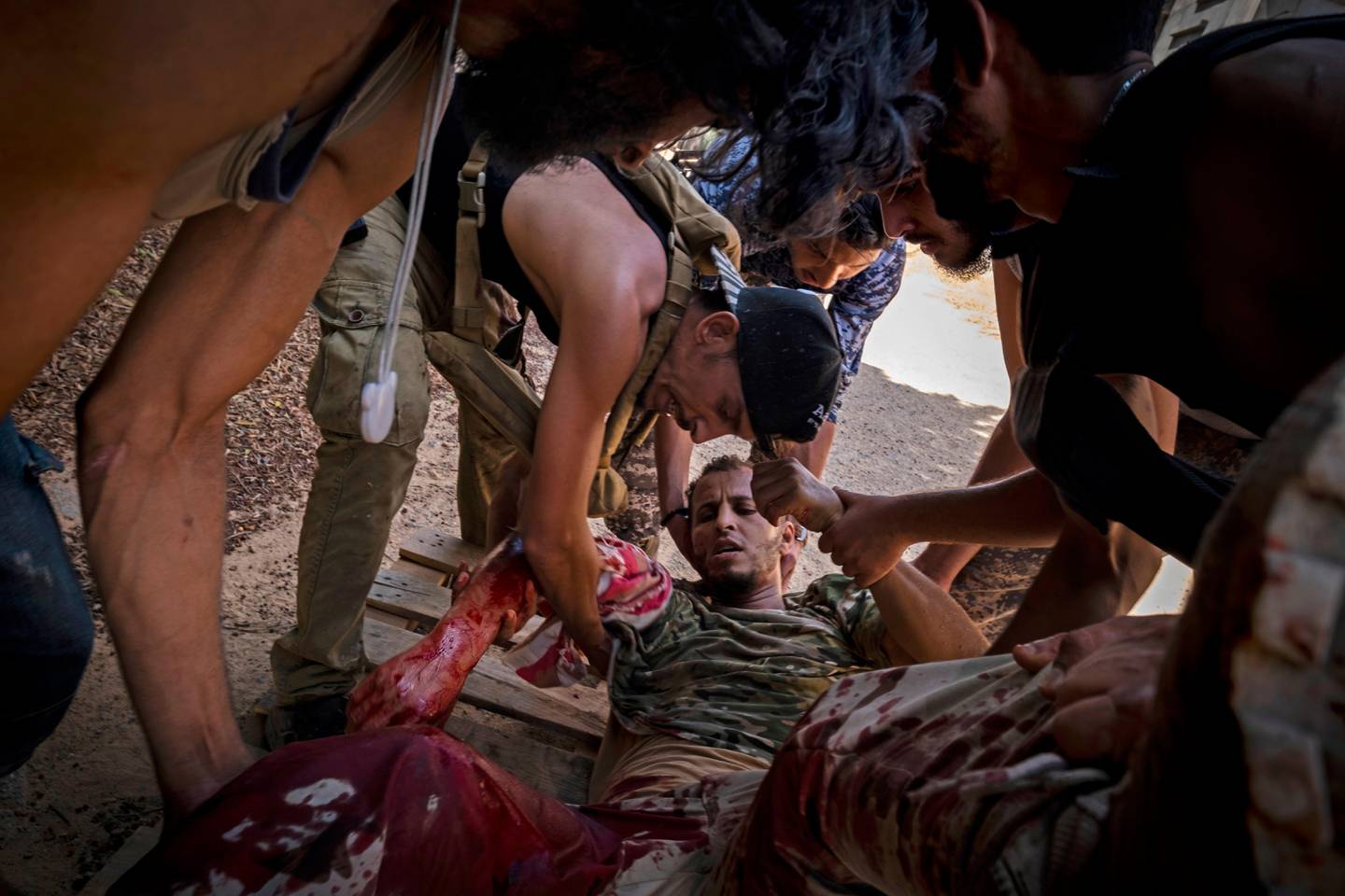 FILE - In this Sept. 7, 2019 file, photo, a mortally wounded fighter of the 'Shelba' unit, allied with the U.N-supported Libyan government, is moved by comrades after being shot at the Salah-addin neighborhood front line, in Tripoli, Libya. Officials in Libyas U.N.-backed administration say they plan to present evidence to Moscow of Russian mercenaries fighting alongside their adversary in their countrys war. Libyan officials say up to 800 fighters from the Russian private security contractor Wagner Group have joined the forces of Hifter, the commander of forces battling for months trying to capture Libyas capital, Tripoli.  (AP Photo/Ricard Garcia Vilanova, File)