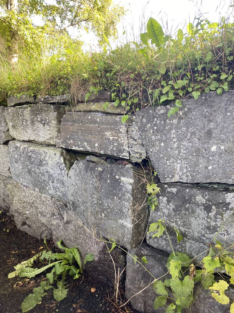 En stein som stikker lengre ut enn de andre steinene i muren.