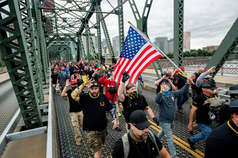 Members of the Proud Boys and other right-wing demonstrators march across the Hawthorne Bridge during an "End Domestic Terrorism" rally in Portland, Ore., on Saturday, Aug. 17, 2019. Police have mobilized to prevent clashes between conservative groups and counter-protesters who converged on the city. (AP Photo/Noah Berger)