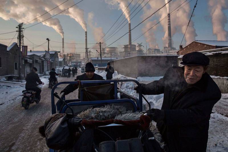 Kina står for verdens største utslipp av CO2, mye takket være et enormt stort forbruk av skittent kull. I år skal over tusen kullgruver legges ned. Bildet har vunnet en av World Press Photo-prisene for 2015 og viser kinesiske menn foran et kullkraftverk i Shanzi i Kina. FOTO: KEVIN FRAYER/NTB SCANPIX