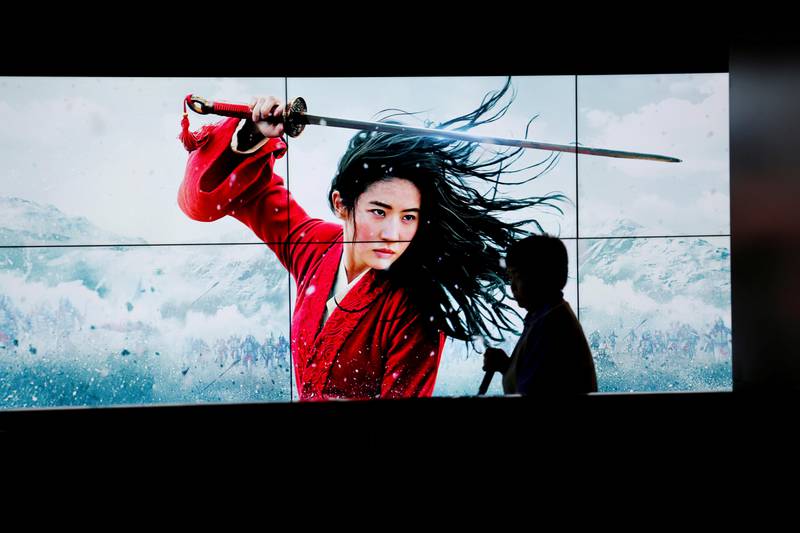FILE PHOTO: A cleaner walks past screens promoting Disney's movie "Mulan" as the film opens in China, at a cinema in Beijing, China September 11, 2020. REUTERS/Florence Lo/File Photo