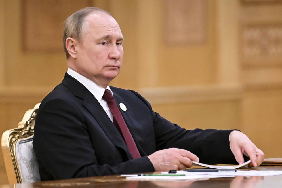 Putin sitter bak et skrivebord med et alvorlig ansiktsuttrykk.