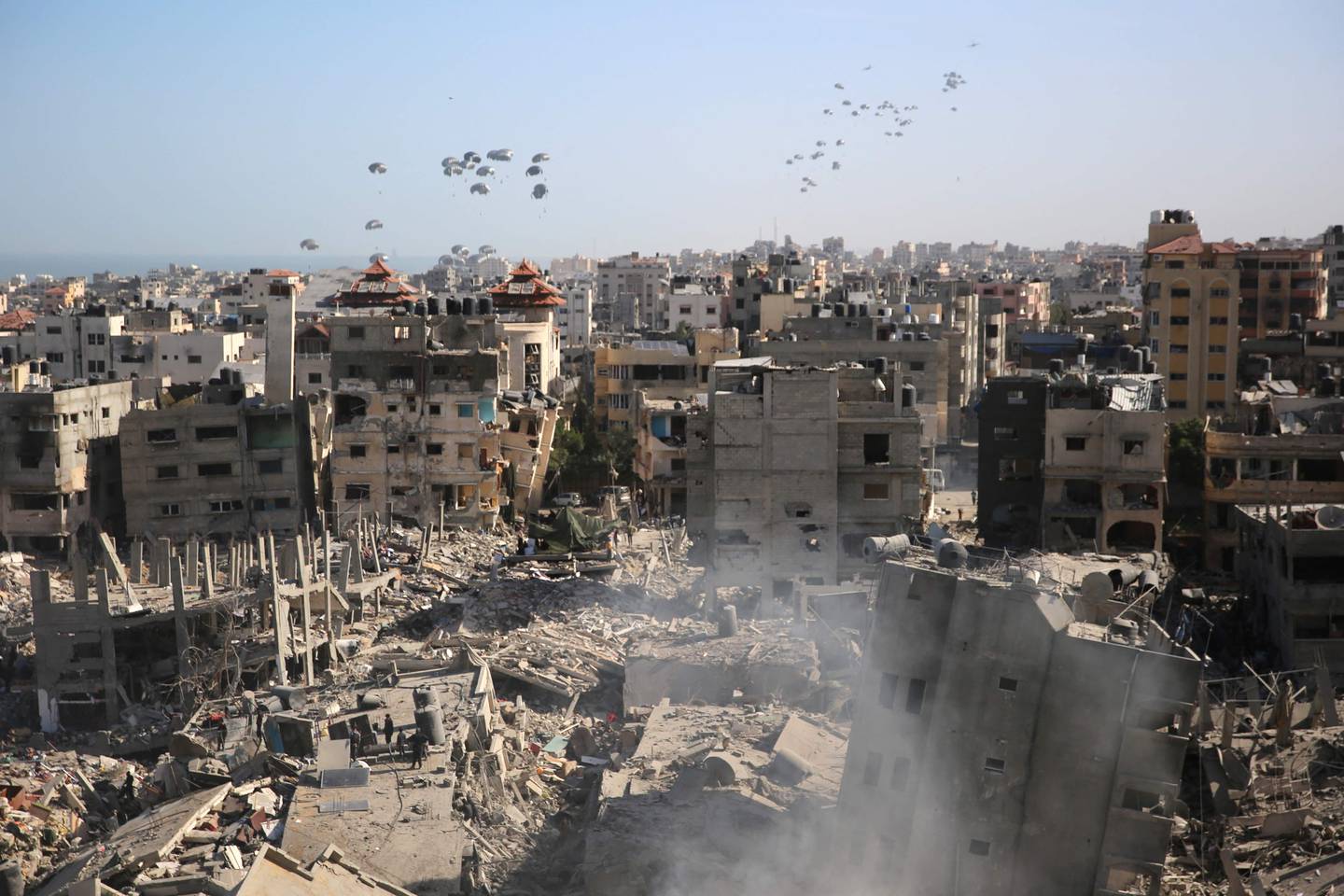 Humanitarian aid is dropped over the Gaza Strip as seen from Al-Shifa hospital after the Israeli military withdrew from the complex housing the hospital on April 1, 2024, amid the ongoing battles Israel and the Hamas militant group. (Photo by AFP)