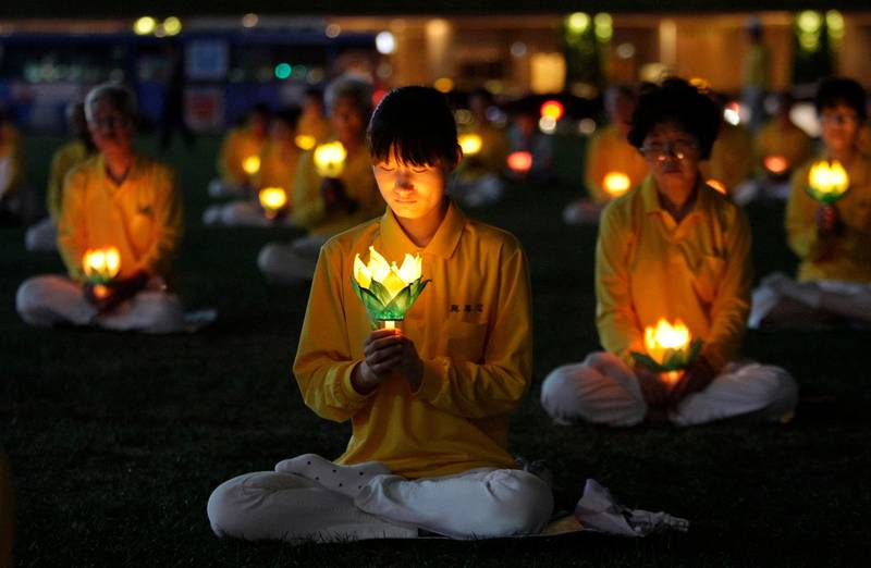 Falun Gong practitioners hold lit candles during a protest against what they say is the Chinese government's policy of harassment and torture of its members in China, in Seoul, South Korea, Wednesday, July 20, 2011. (AP Photo/Ahn Young-joon)
