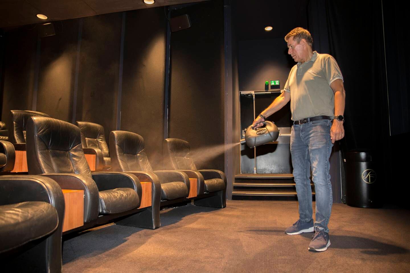 Kinodirektør Håvard Erga ved Odeon Kino Stavanger/Sandnes sprayer her luksussalen på Sølvberget fritt for bakterier og virus.