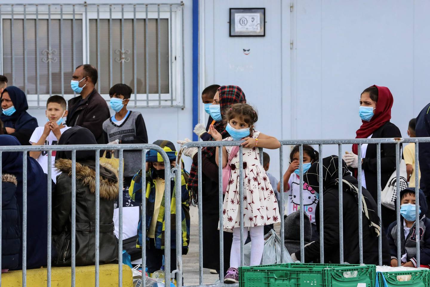 (FILES) In this file photo taken on May 3, 2020 migrants wait at the port of Mytilene to be transferred from the island of Lesbos to the Greek main land in Moria. - Greece will extend to May 21 a coronavirus lockdown imposed since March on migrant camps and which had been expected to be lifted from May 11, 2020, the authorities said. "The coronavirus measures of confinement for those living in migrant camps and in reception centres in Greece are prolonged until May 21," the migration and asylum ministry said in a statement on Sunday, six days after the first easing of the general lockdown in the country. The ministry did not say why the camp lockdown was being extended. (Photo by Manolis Lagoutaris / AFP)