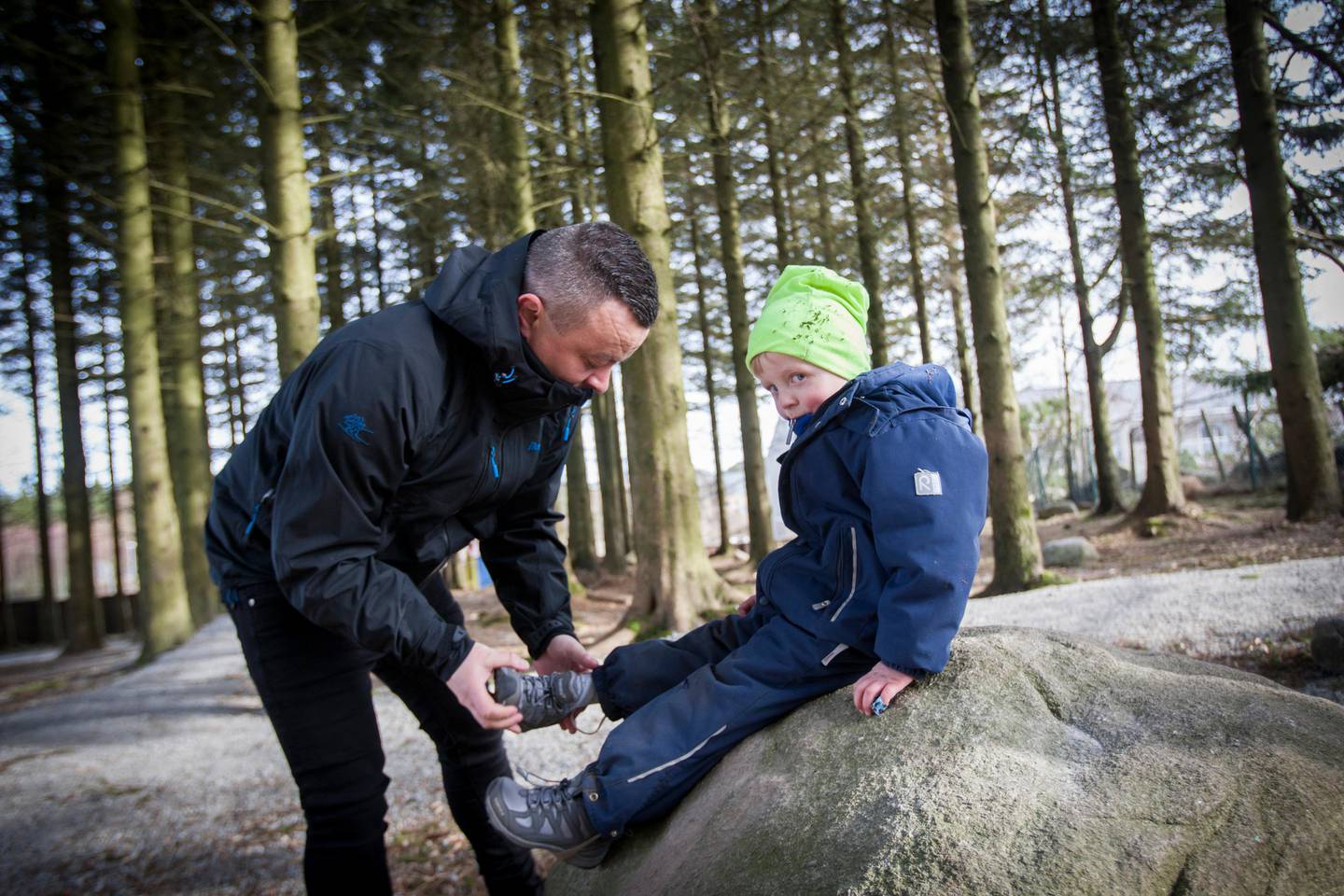 Pedagogisk leder Ingve Bokn hjelper William (4) med å få på seg skoen igjen etter å ha lekt ute i skogsområdet.