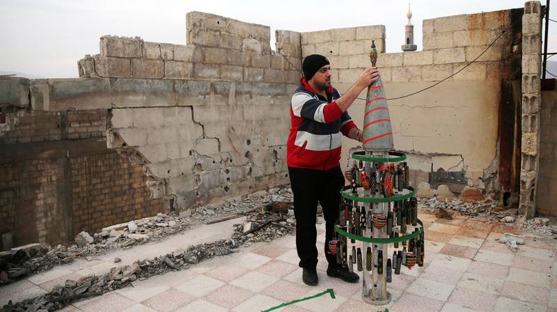 Akram Abu Al-Foz dekorerer et juletre laget av granathylser han har samlet og tegnet på, i den opprørskontrollerte byen Douma øst for Damaskus. Det forsøkes på en våpenhvile i Syria.