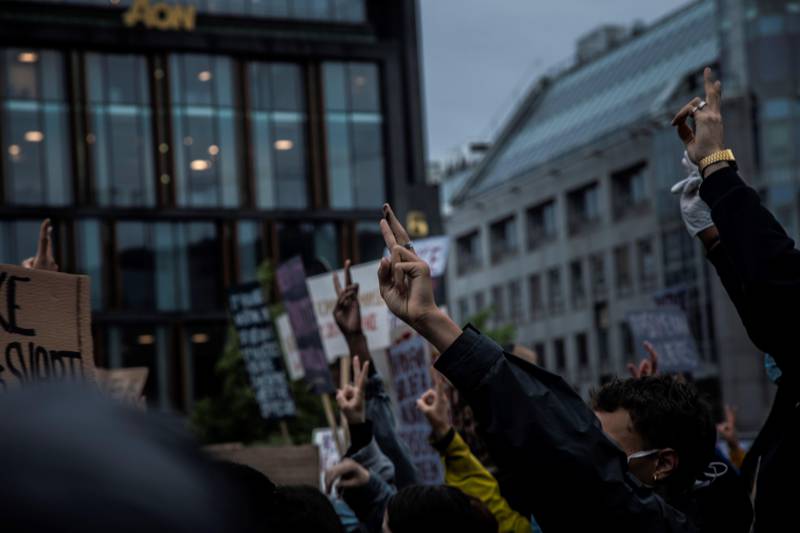 Flere demonstranter løftet hånden sin for å lage fredstegn.