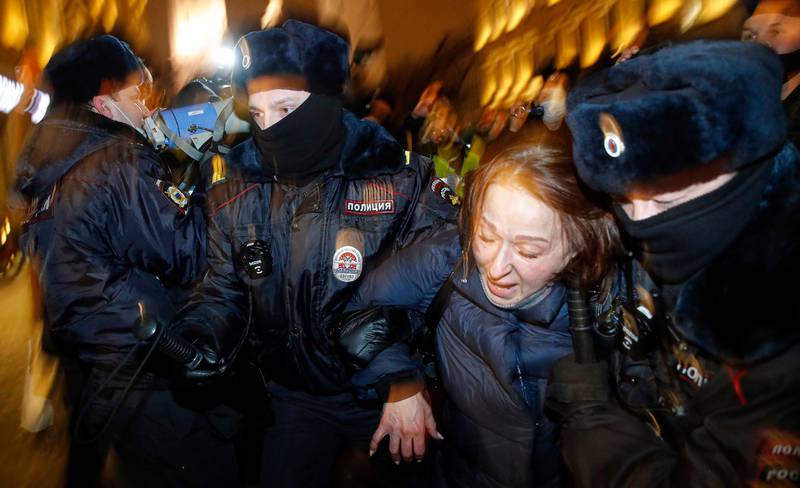 Police officers detain a Navalny supporter during a protest in St. Petersburg, Russia, Tuesday, Feb. 2, 2021. A Moscow court has ordered Russian opposition leader Alexei Navalny to prison for more than 2 1/2 years on charges that he violated the terms of his probation while he was recuperating in Germany from nerve-agent poisoning. Navalny, who is the most prominent critic of President Vladimir Putin, had earlier denounced the proceedings as a vain attempt by the Kremlin to scare millions of Russians into submission. (AP Photo/Dmitri Lovetsky)