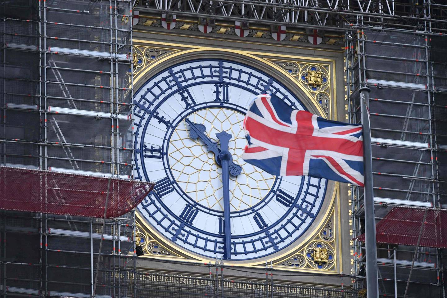 The Union flag flutters near the clockface of Big Ben during ongoing renovations to the Tower and the Houses of Parliament, in central London on January 17, 2020. (Photo by DANIEL LEAL-OLIVAS / AFP)