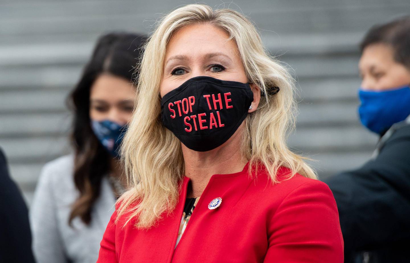 (FILES) In this file photo taken on January 4, 2021 US Representative Marjorie Taylor Greene, Republican of Georgia, holds up a "Stop the Steal" mask while speaking with fellow first-term Republican members of Congress on the steps of the US Capitol in Washington, DC. - A newly elected Republican congresswoman known for promoting QAnon conspiracy theories accused Twitter of censorship on January 17, 2021 after her account was temporarily suspended for "multiple violations". Marjorie Taylor Greene was hit with the 12-hour suspension after she tweeted claims of alleged election fraud in Georgia, her home state. (Photo by SAUL LOEB / AFP)